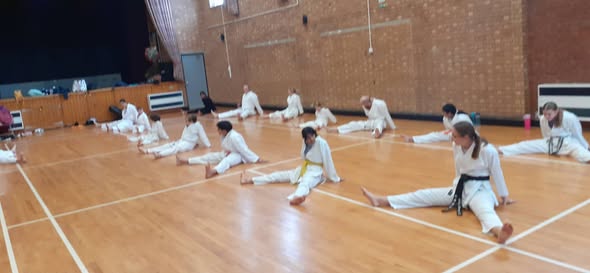 Karate students stretching during class at Shotokan Karate Dojo
